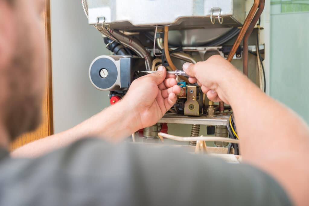 Trusted HVAC tech performing furnace installation